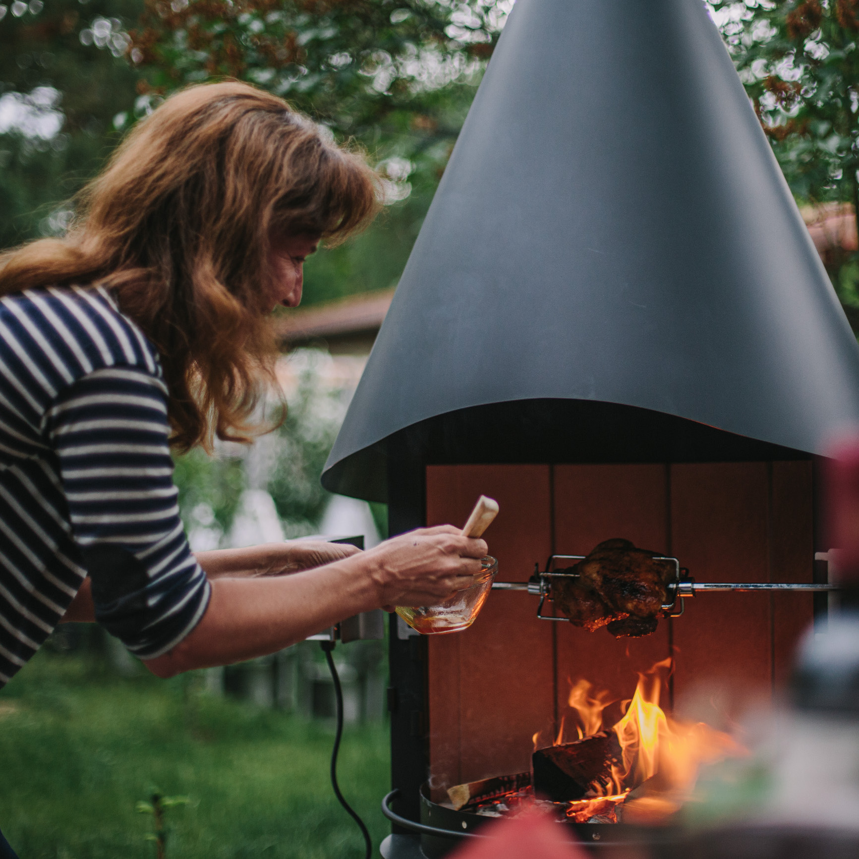 Der Grillkamin Zenit mit elektrischem Grillspieß. Das Bild verdeutlicht die Langlebigkeit der Grillkamin.